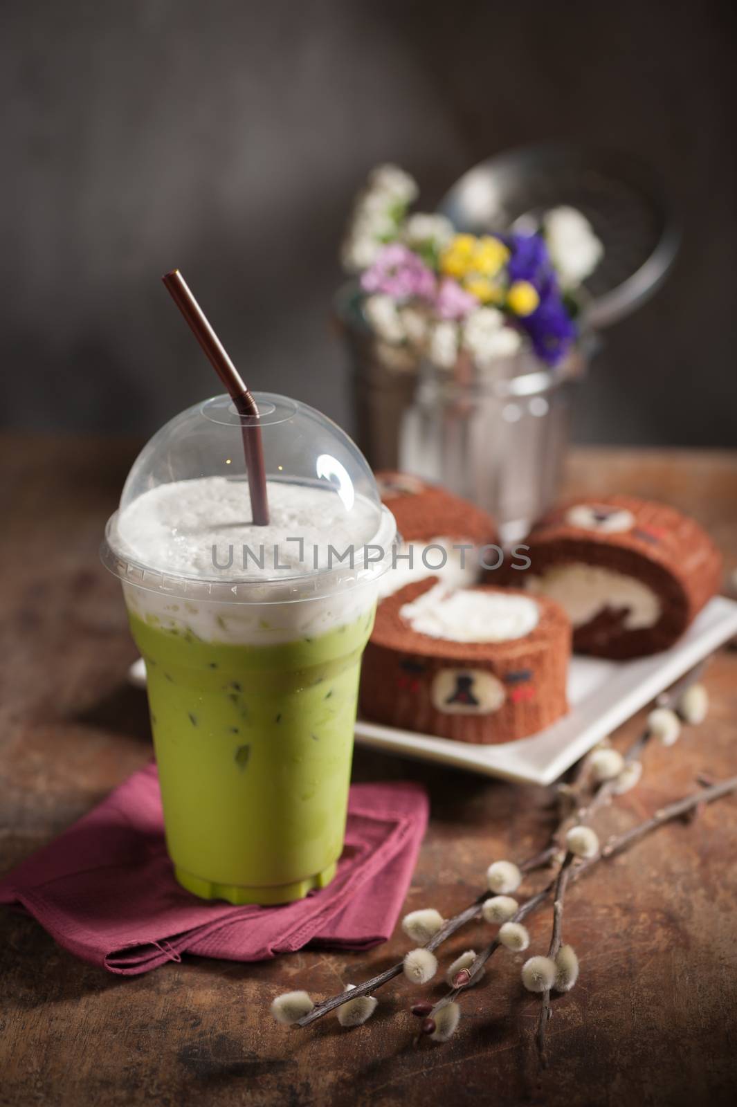 Iced green tea latte on wood table with low key scene