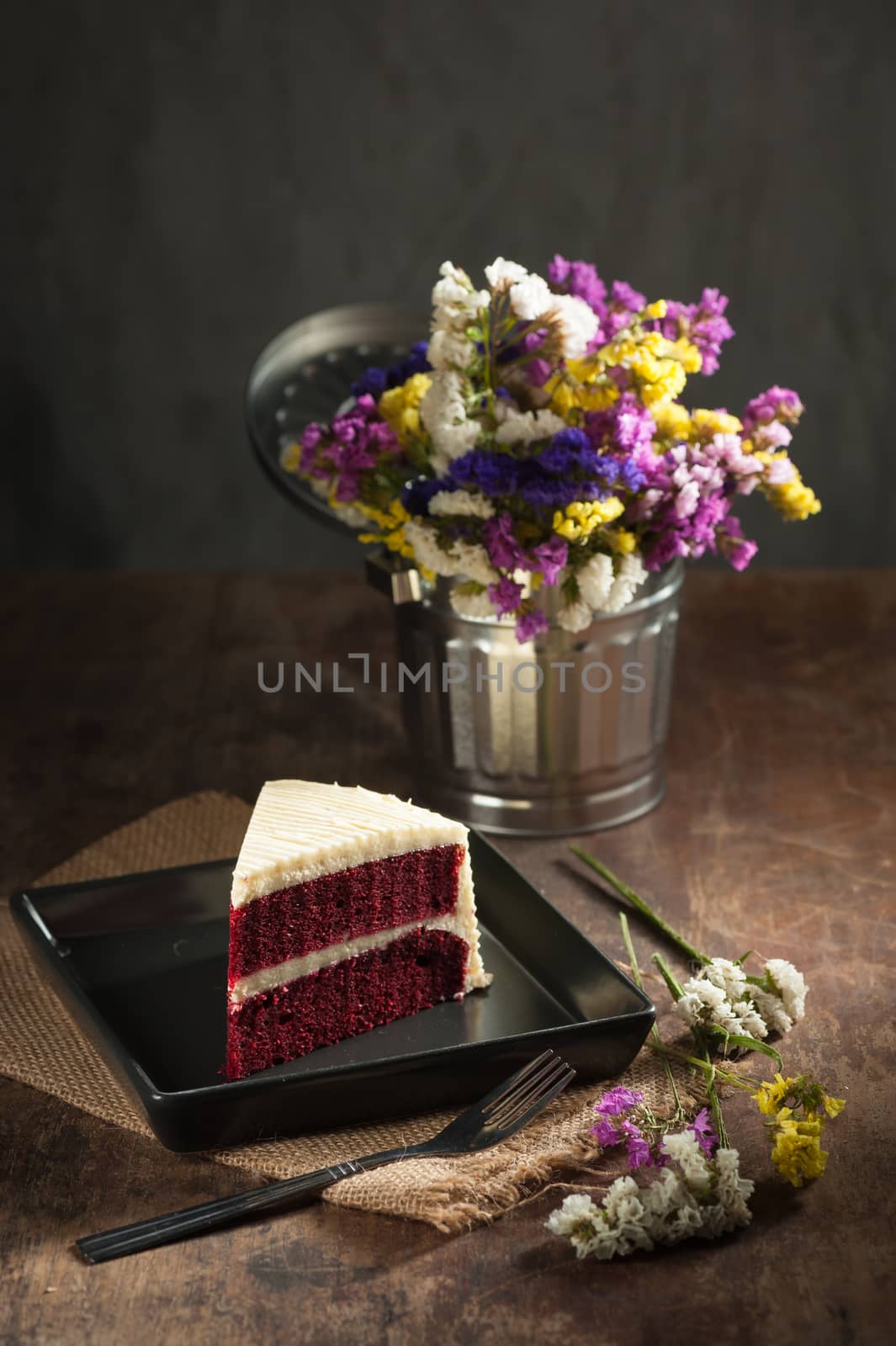 Red velvet cake on wood table with low key scene
