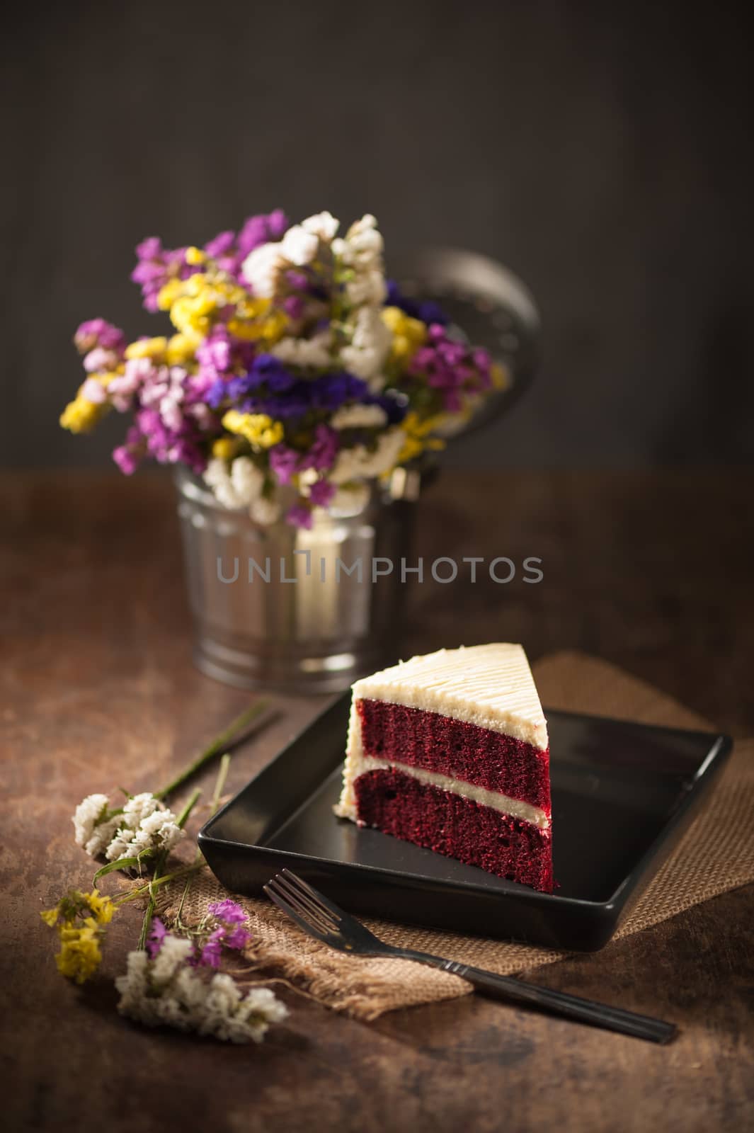 Red velvet cake on wood table with low key scene