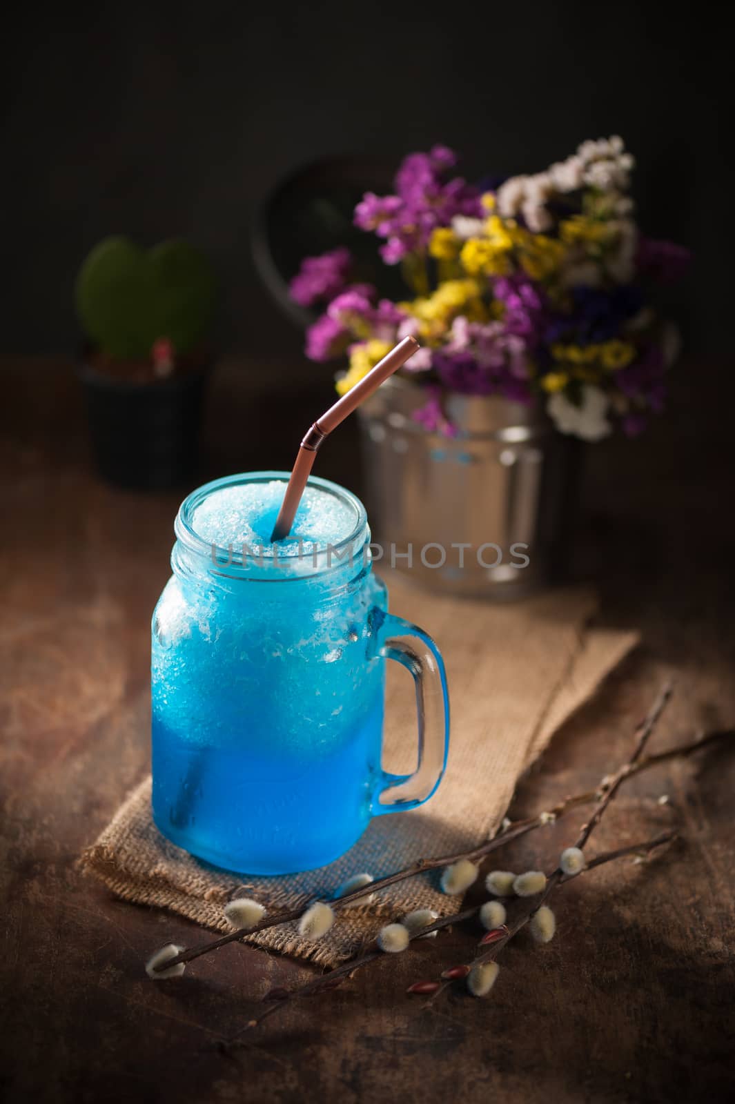 Blue cocktail frozen on wood bar in cafe