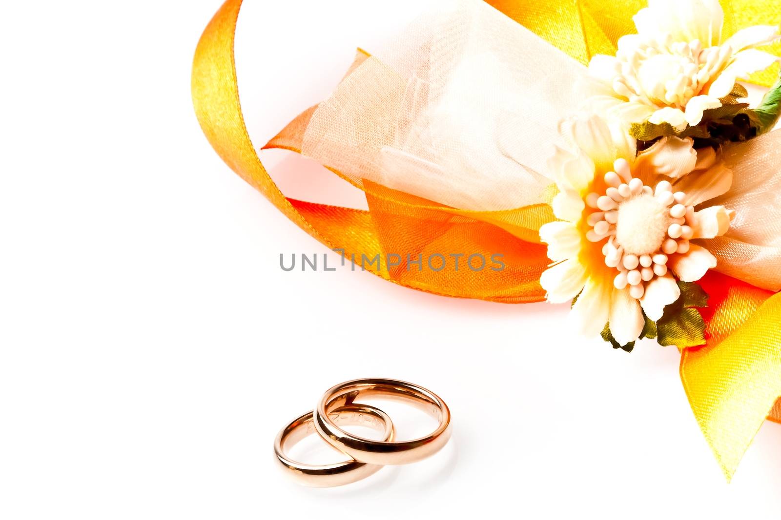 gold wedding rings near ribbon and flowers with space for text by donfiore