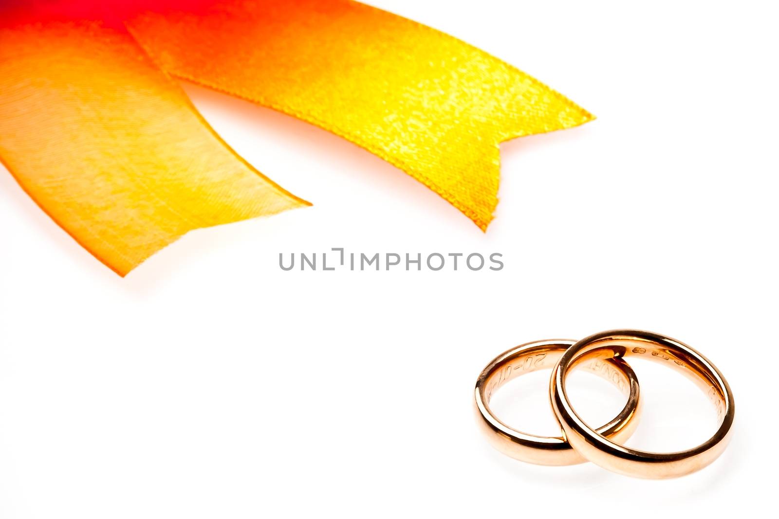 gold wedding rings near ribbon with space for text on white background