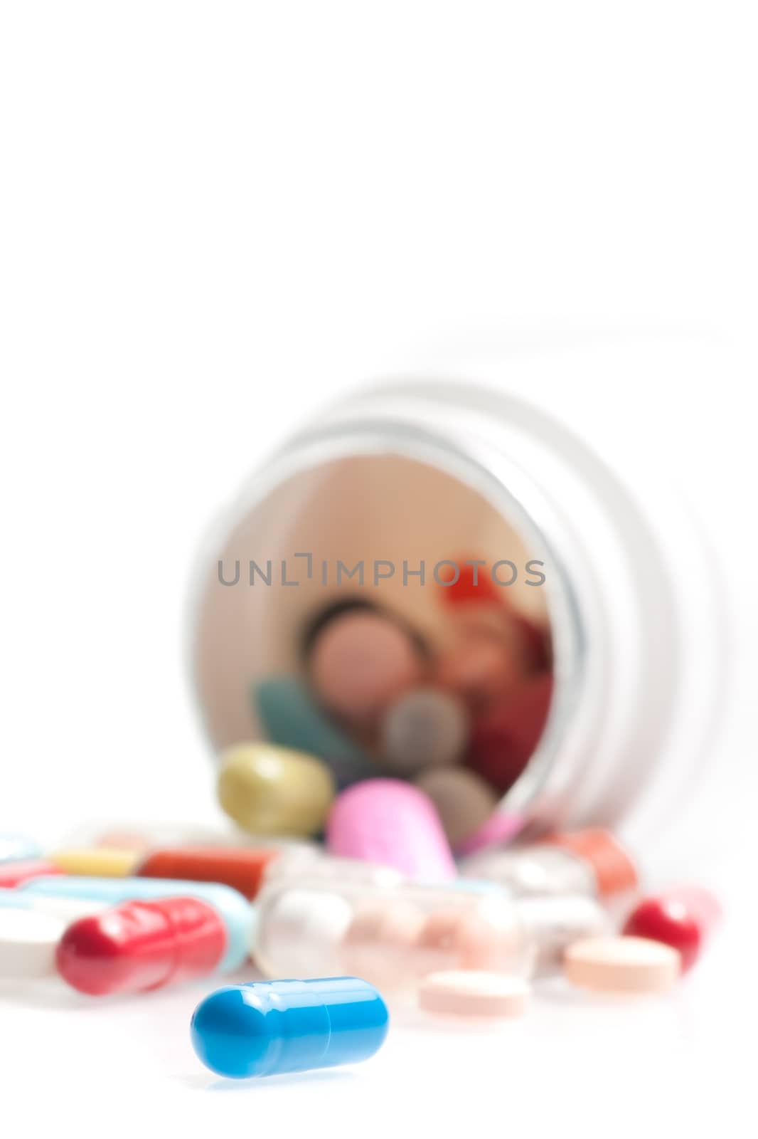 blue pill in laboratory in front of a colored pills on white table