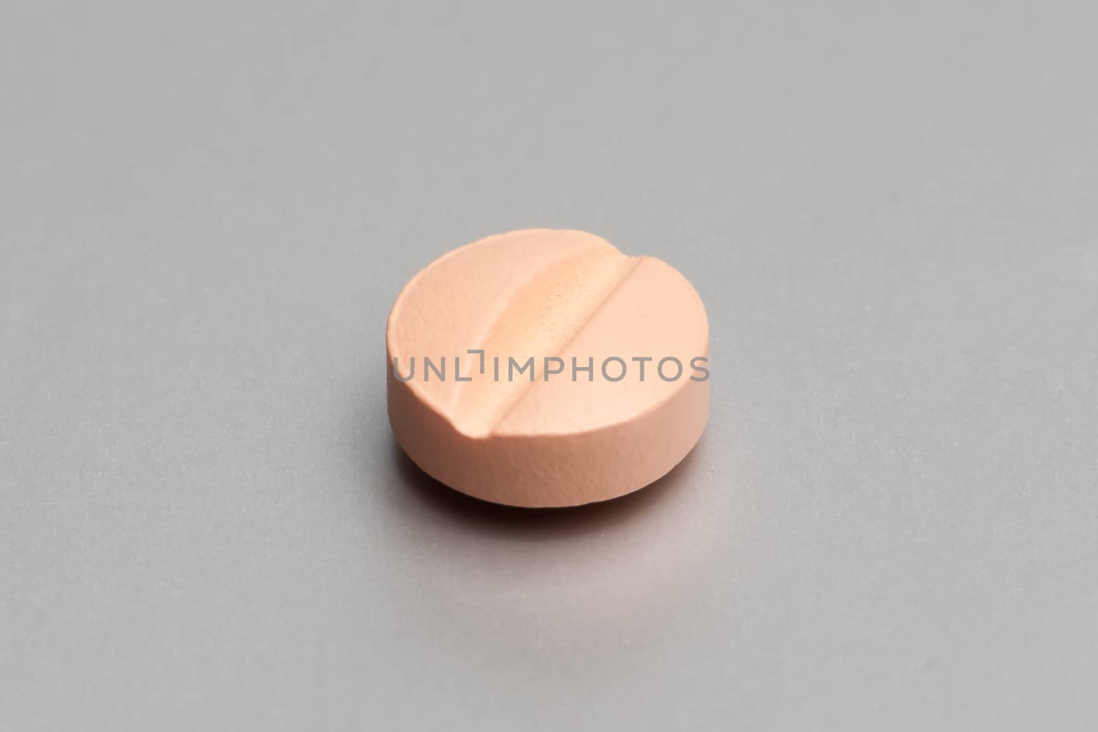 pink medical pill on metallic table 