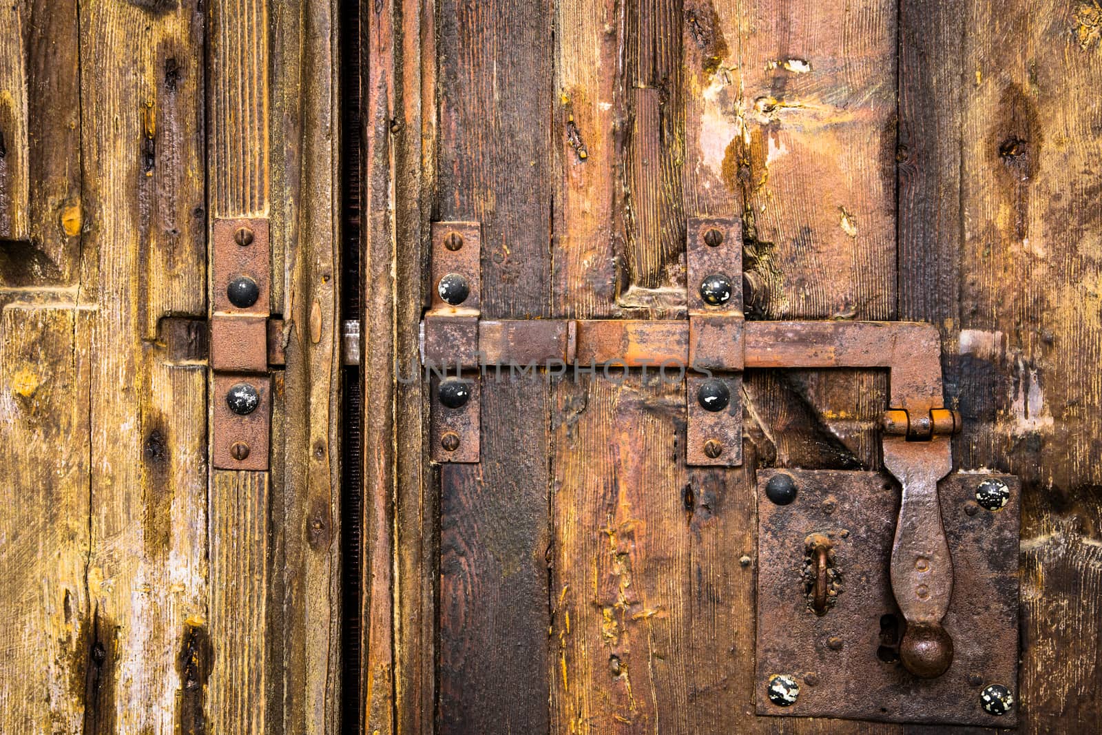 iron rusty deadbolt on old wooden door