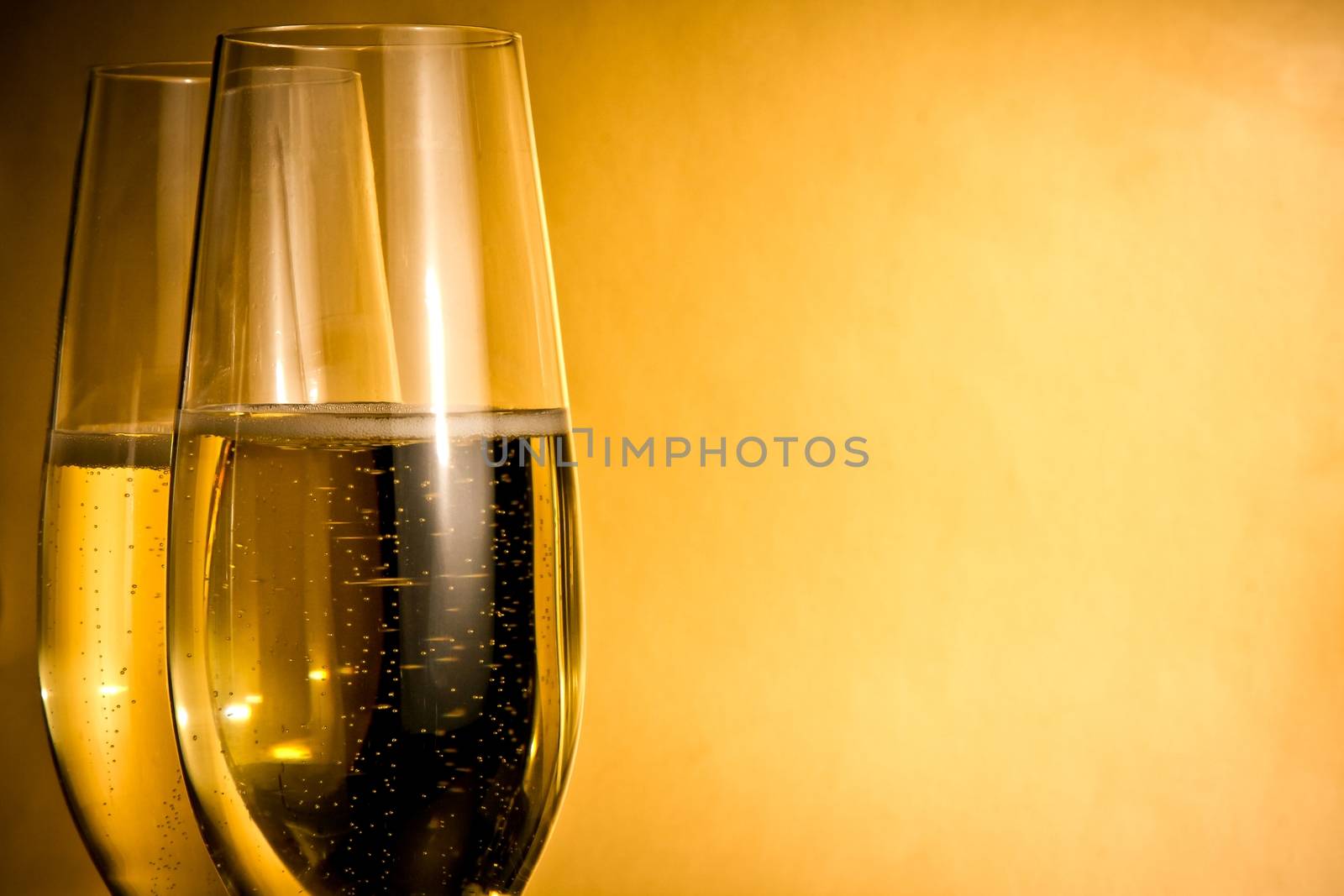 two glasses of champagne with golden bubbles and space for text by donfiore