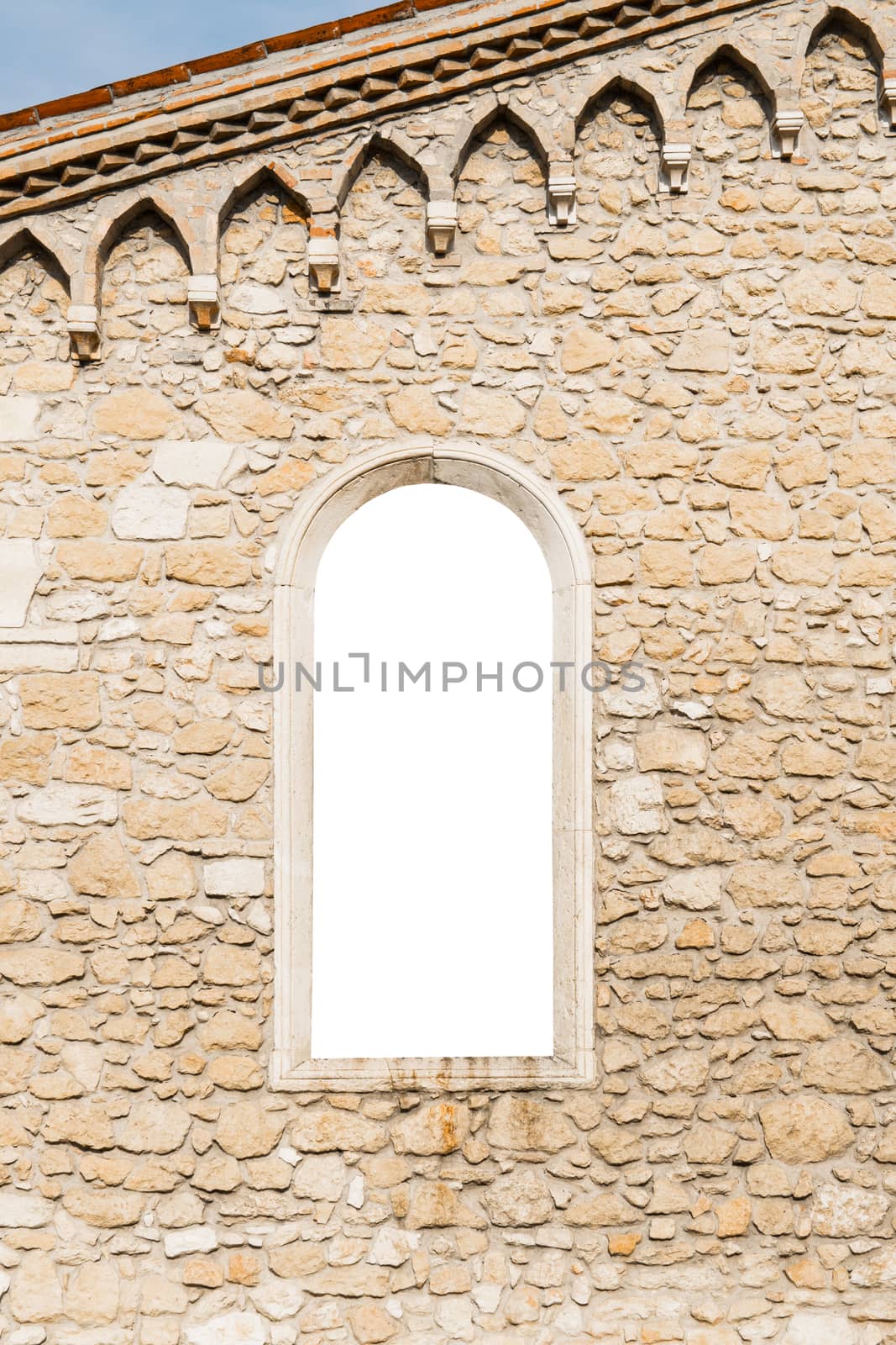 Arched window in the ancient medieval stone wall suitable as a frame or border.