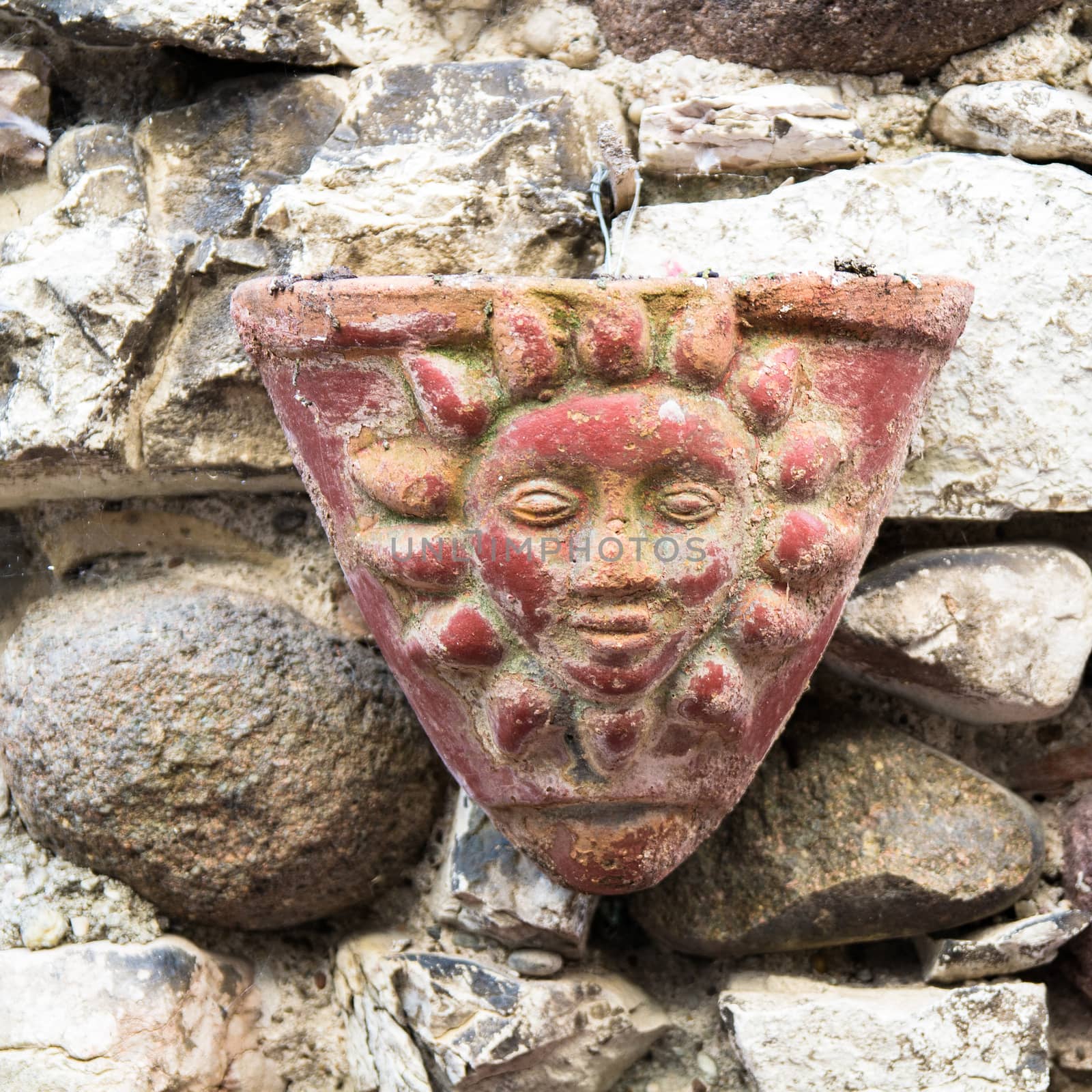 triangle clay pot hanging on a stone wall