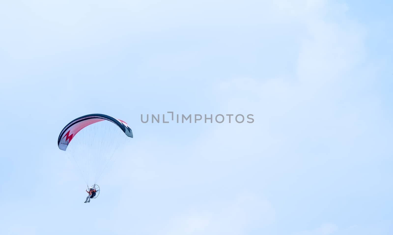 motorized paraglider flying in the blue sky