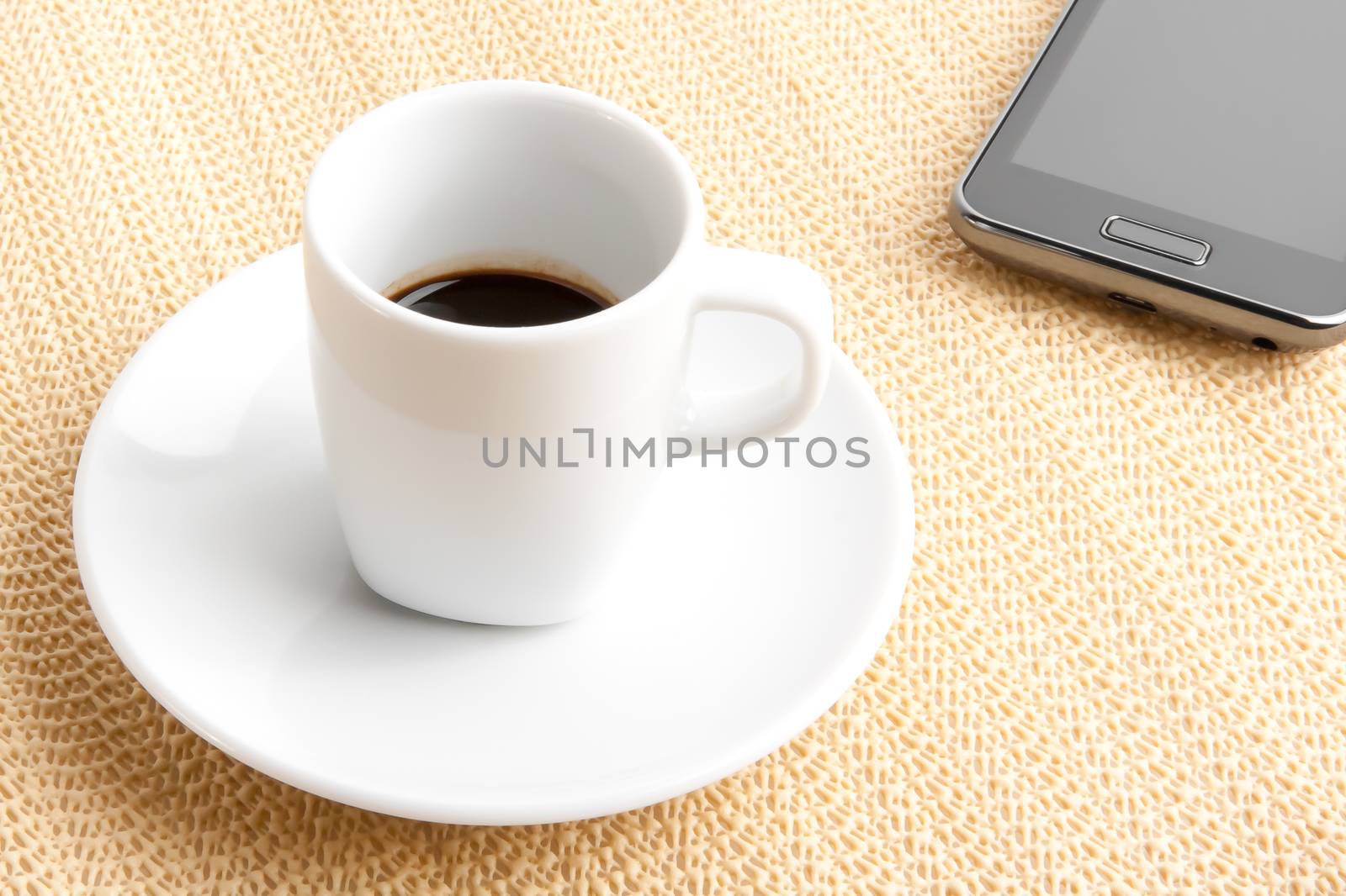 cup of coffee with smartphone on burlap surface