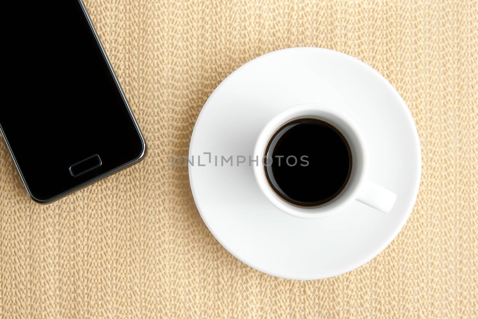cup of coffee with smartphone on burlap surface