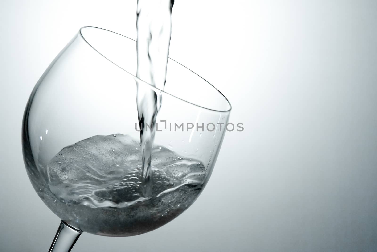 tilted crystal wine glass with white wine on  background drama