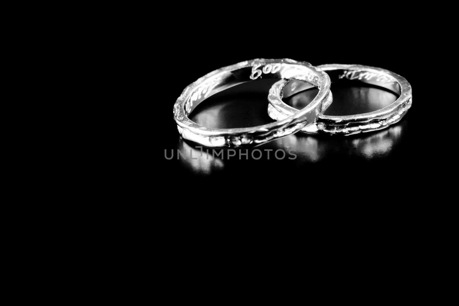 two white gold rings stacked together on black background