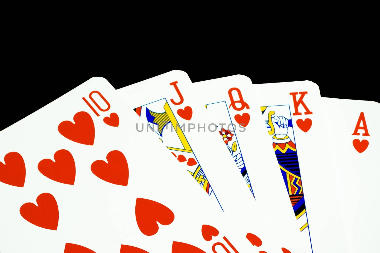 closeup royal flush of hearts on black background