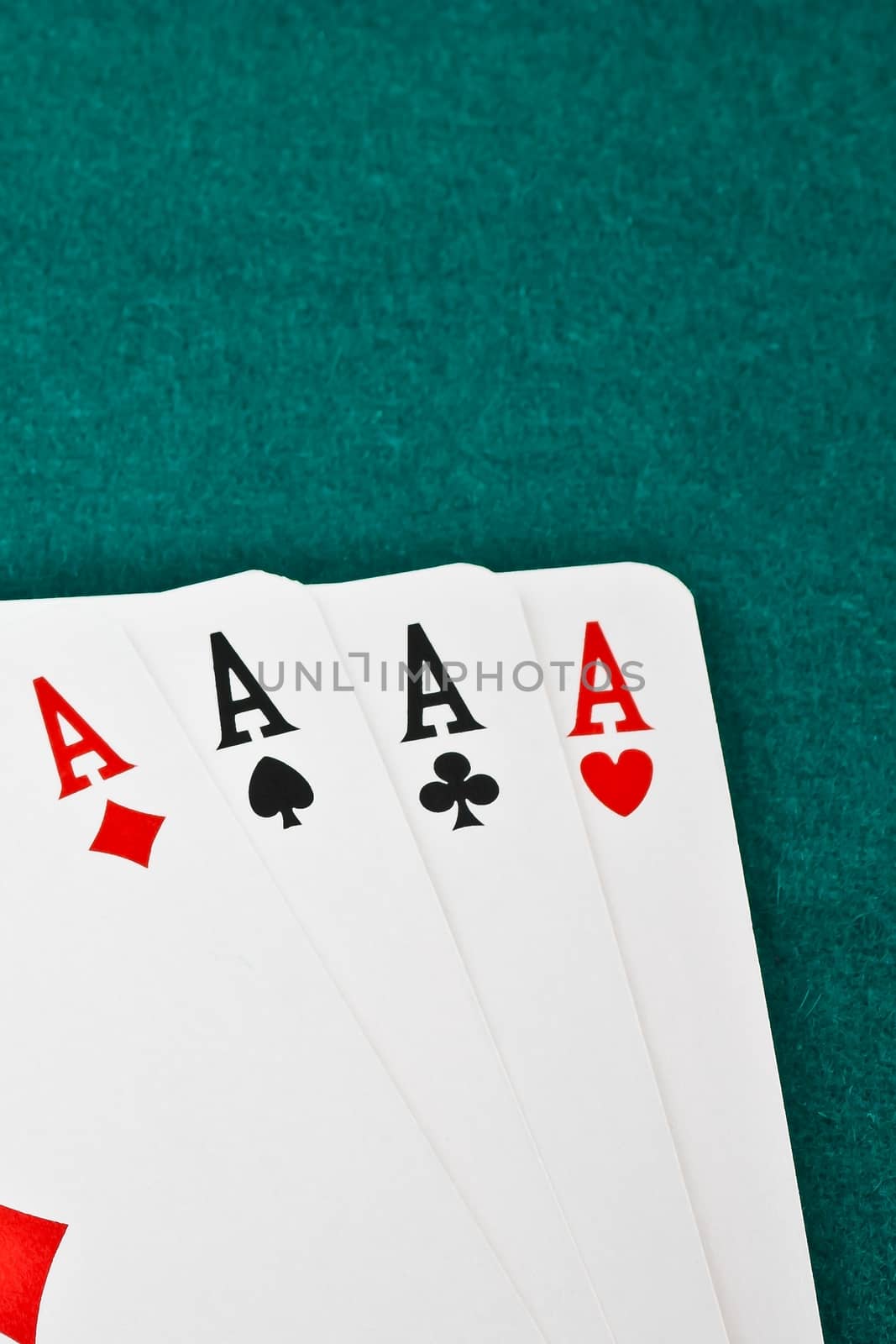 winning poker hand in corner in of a green fabric background 