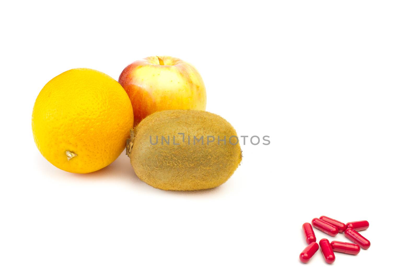 detail of fruit and red pills on white background