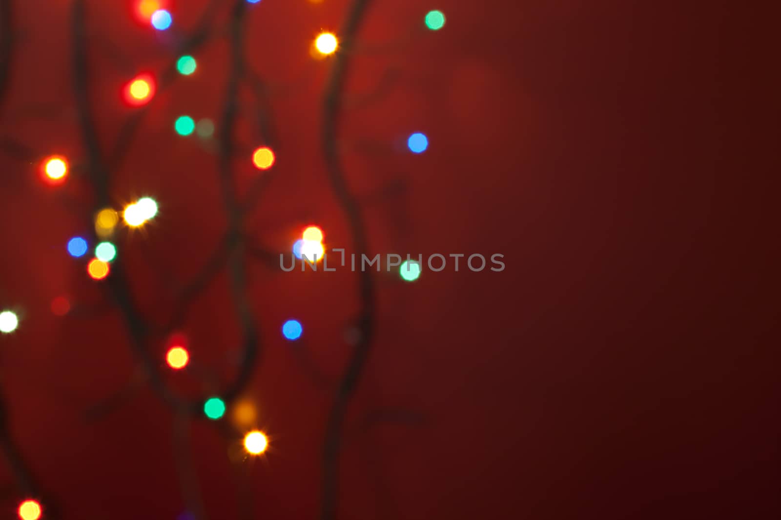 defocused christmas lights on red background with copyspace