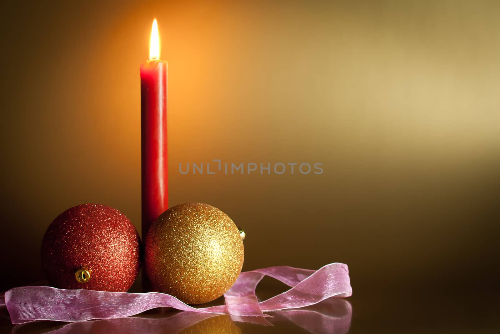 christmas balls with red candle on gold background