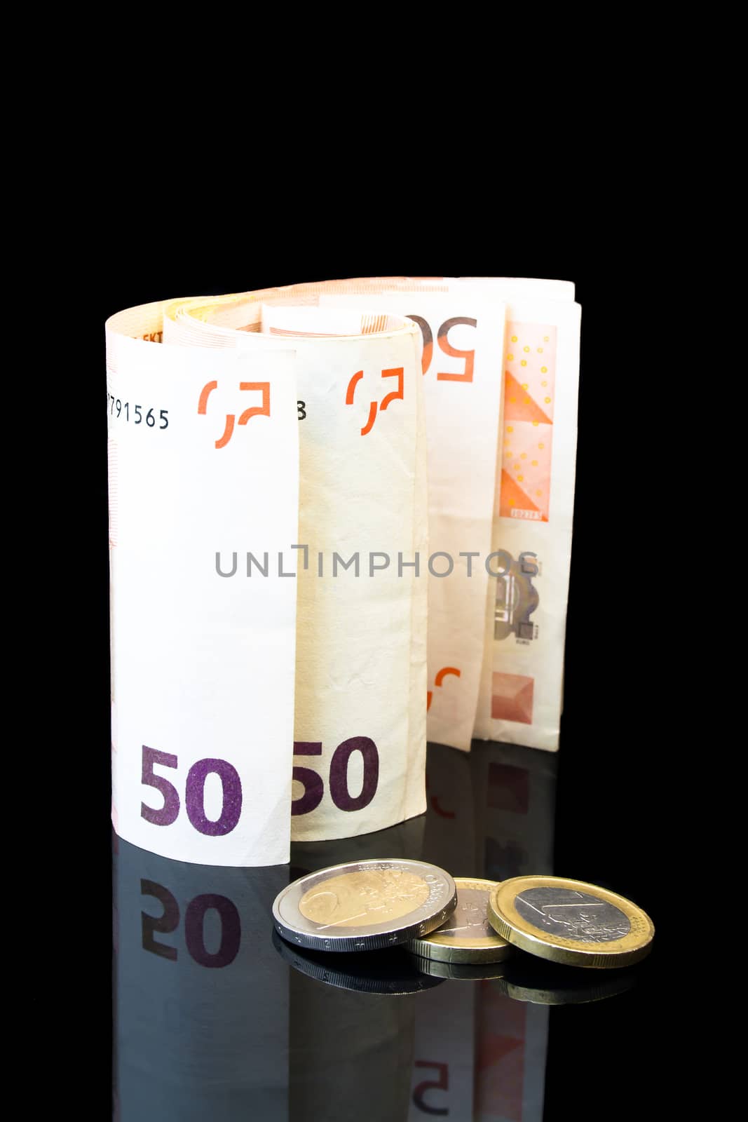 detail of money roll with euro coins on black background