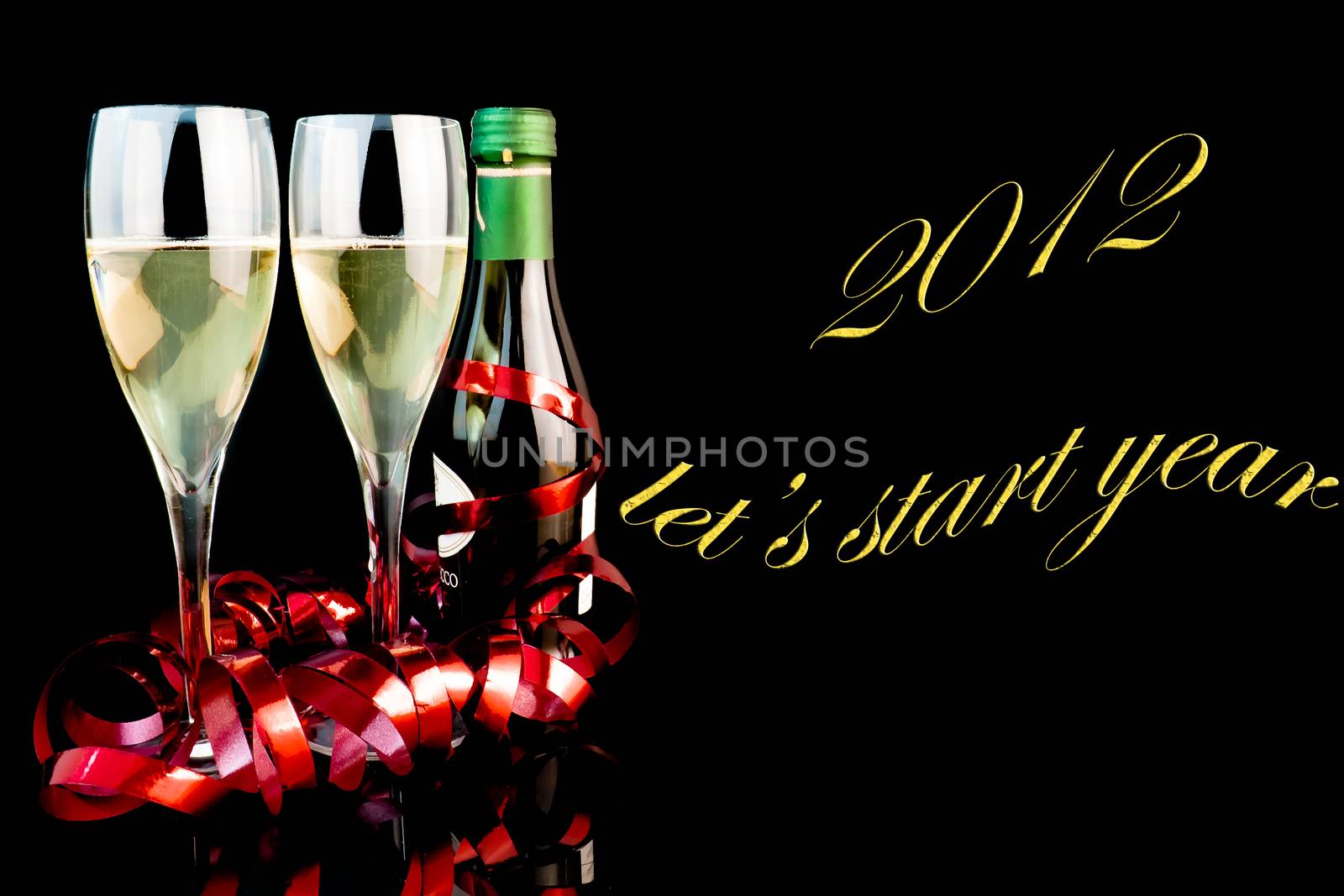 detail of two glasses near a middle bottle of champagne on black background with space for text