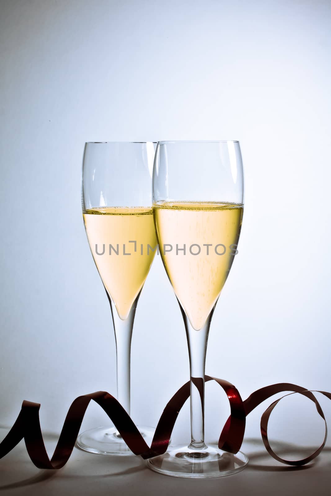 detail of glasses of champagne and christmas decoration on white background