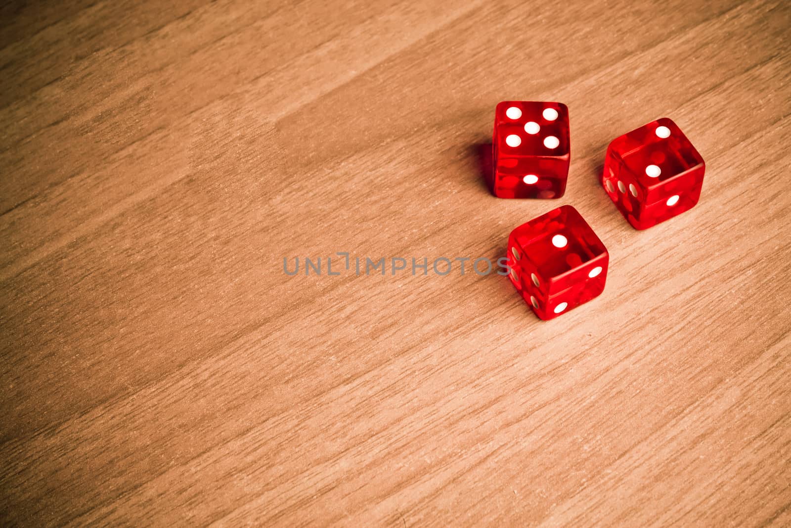 detail of red dice on old wood with space for text