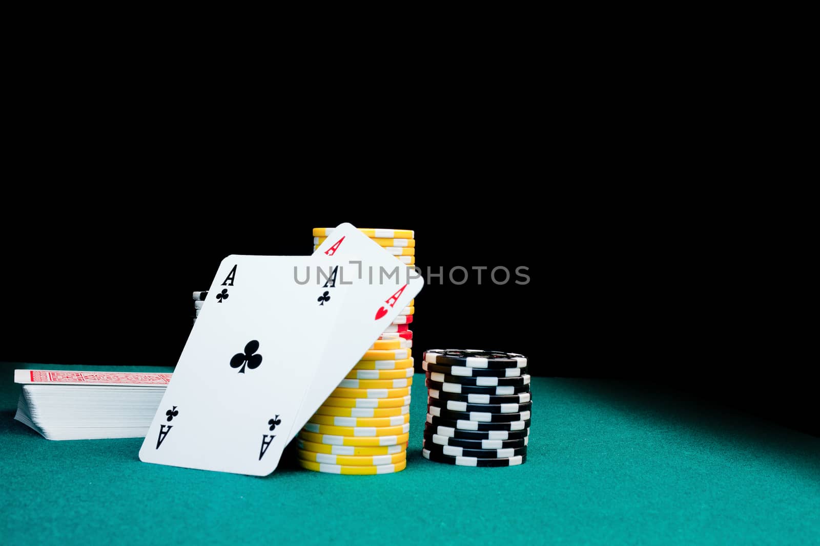 Gambling chips, a stack of cards & two aces