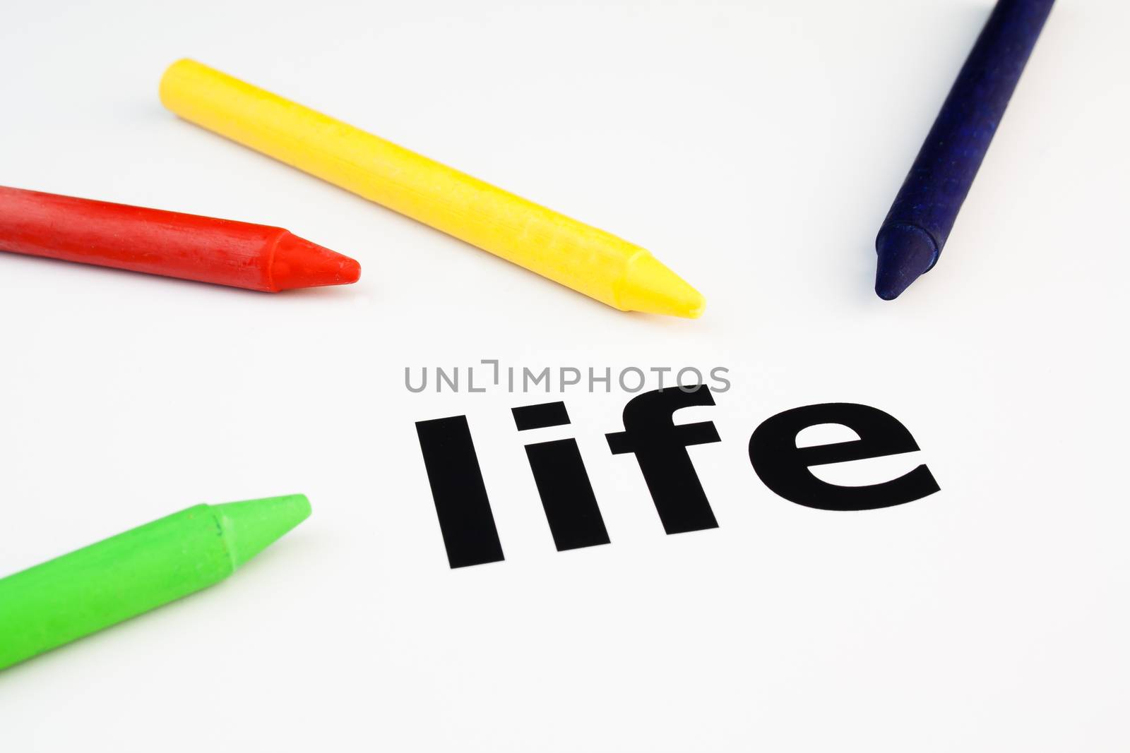 Detail view of colored wax crayons arranged on the word life