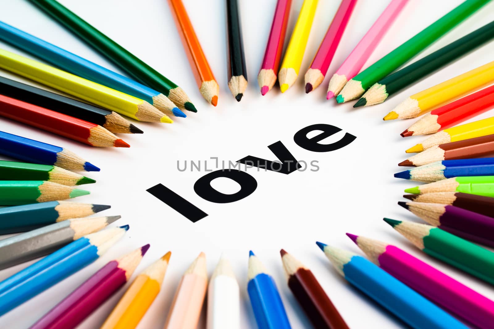 Detail view of many colored pencils arranged in circle on the word love