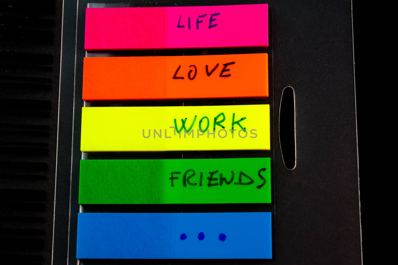 detail of a post-it with write the words life love work friends