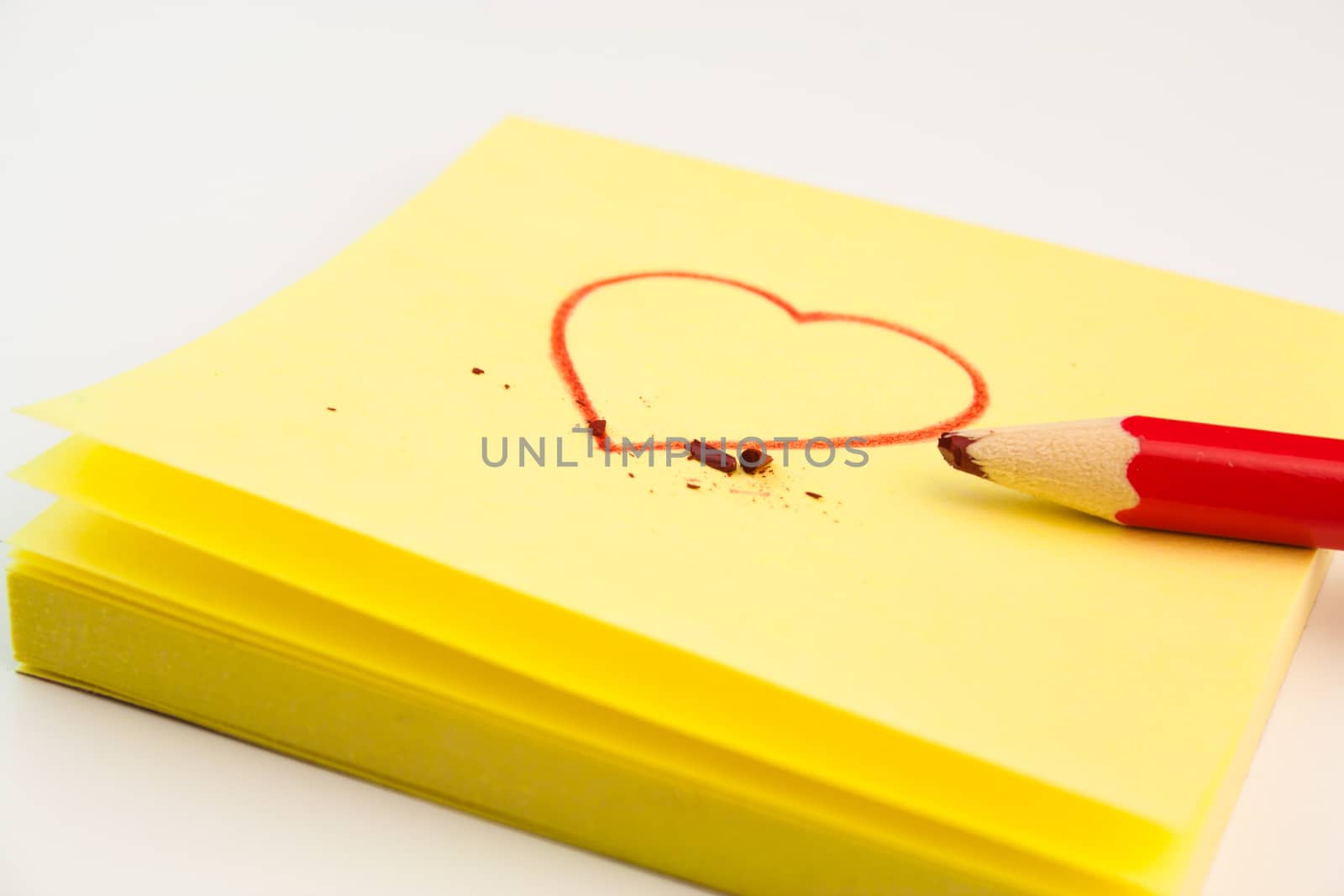 detail of a red heart drawn on a post-it with a pencil
