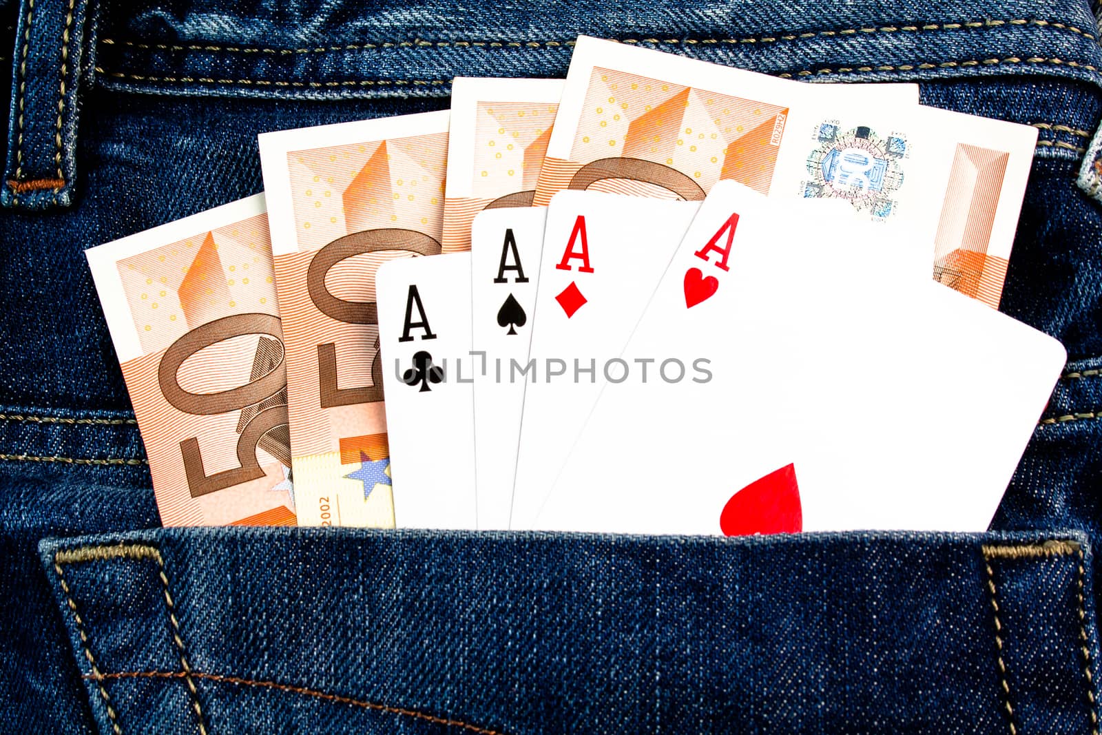 details of four 50 euro Banknotes and poker cards in back pocket jeans