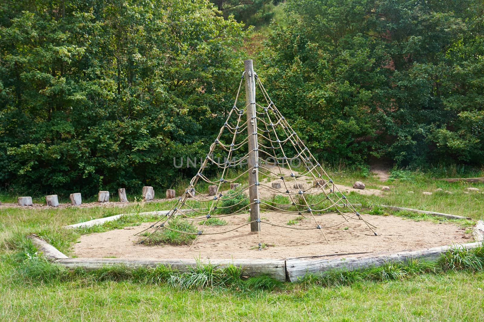 Jungle gym exercise equipment made of wood and ropes in a playground                               