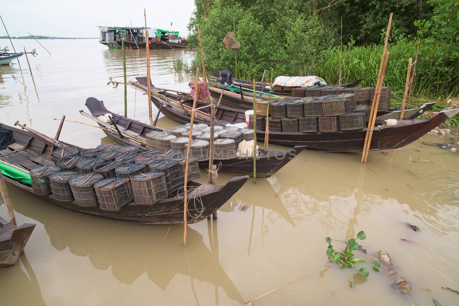 Traditional, wooden boats loaded with fishing gear on the Ywe River in Labutta, a township in the Ayeyarwady Division of Myanmar.