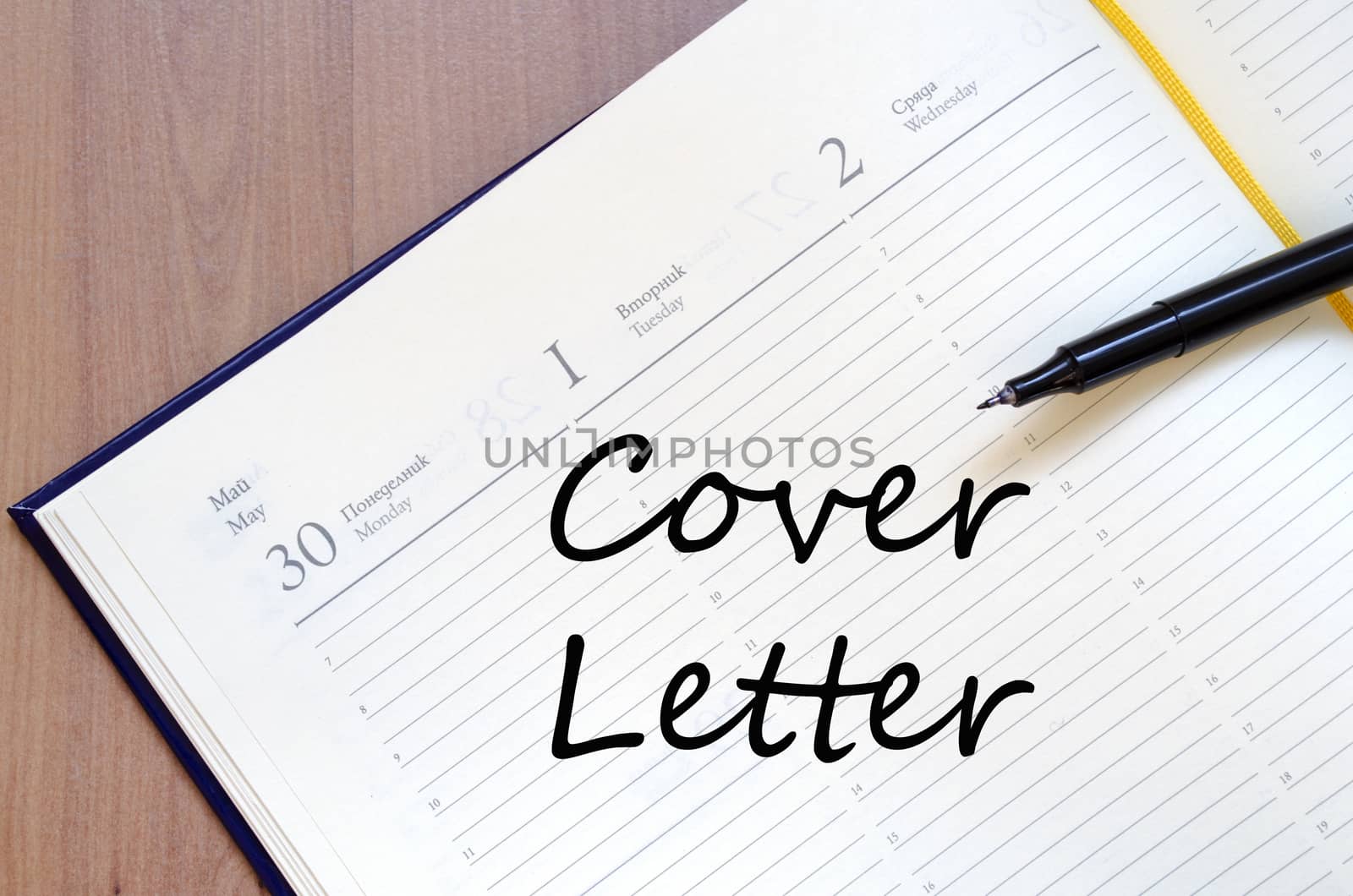 Notepad and pen on wooden background and text concept
