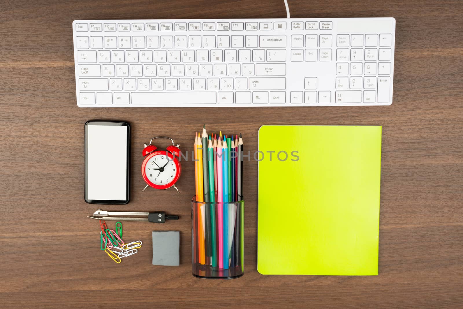 Keyboard with office supplies on wooden table