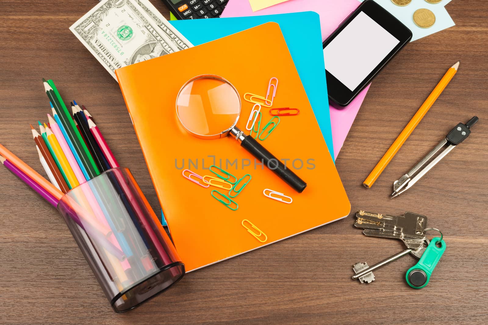 Colorful notebooks with office suppleis on wooden table