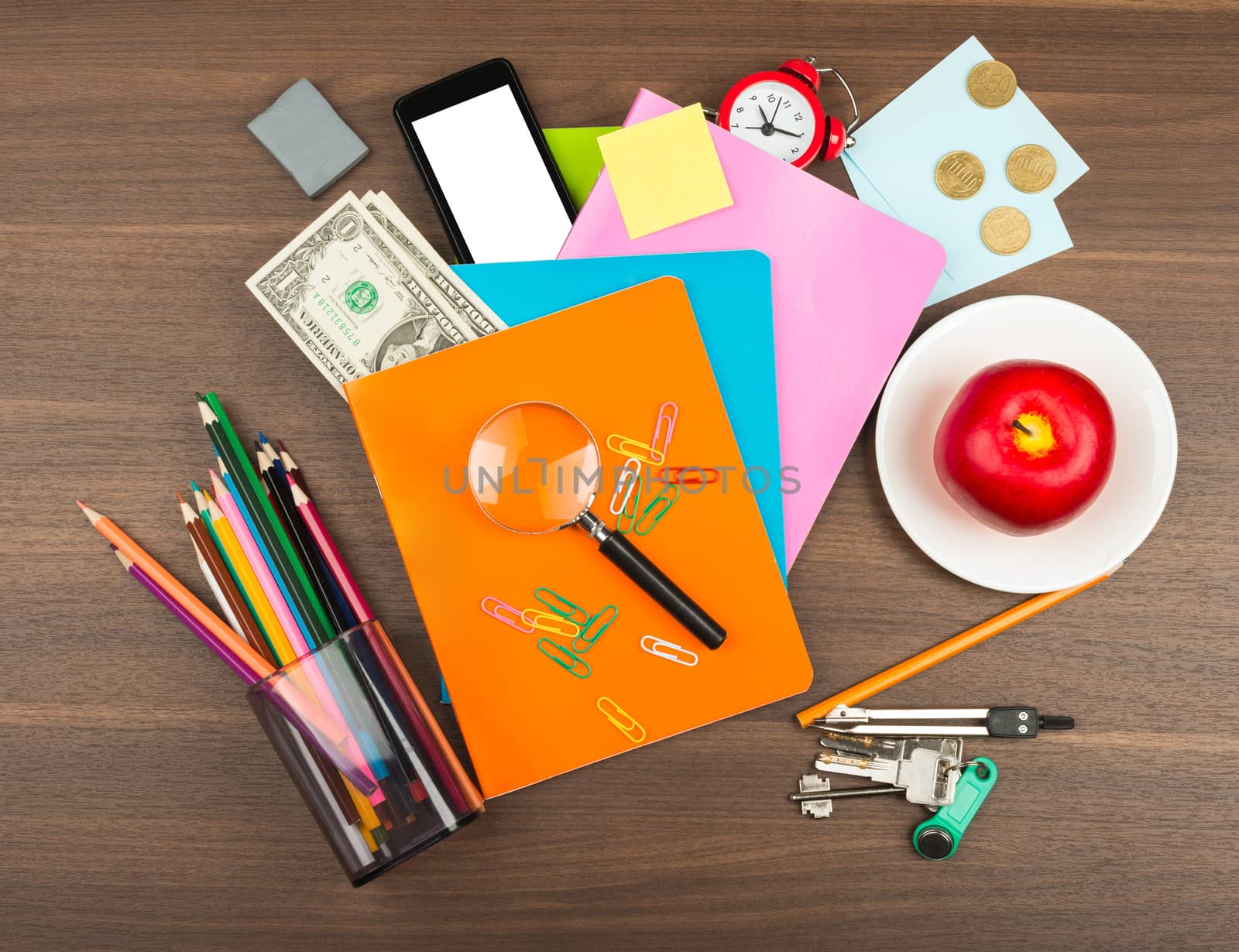 Colorful notebooks with office supplies and apple on wooden table