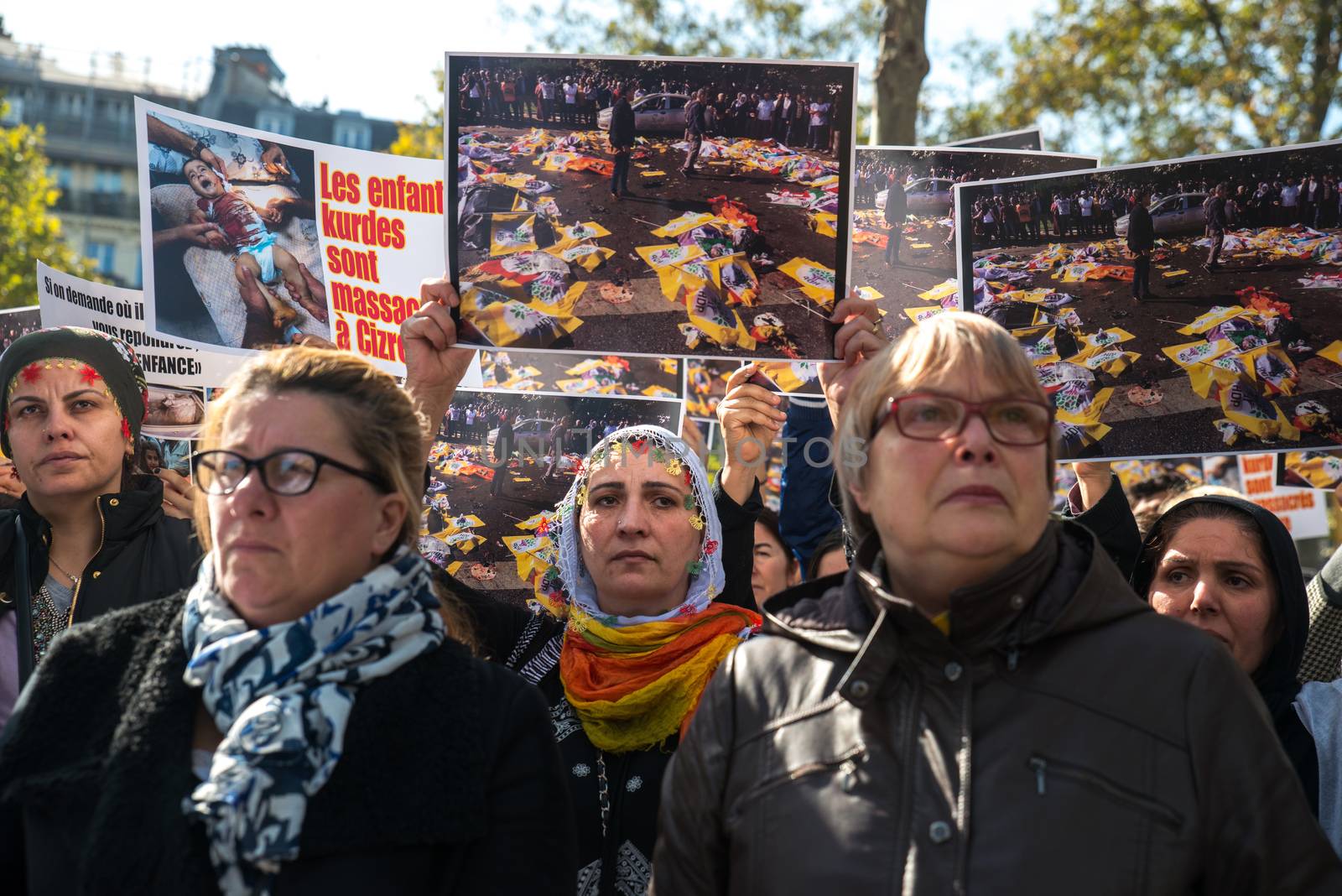 FRANCE, Paris: Several women stand raising the same picture of Ankara terror attack while protesters gather in Place de la R�publique in Paris on October 10, 2015, in tribute to the victims of the terror attack. The same day, at least 95 people died after a twin explosion in the center of the capital city in Turkey. 