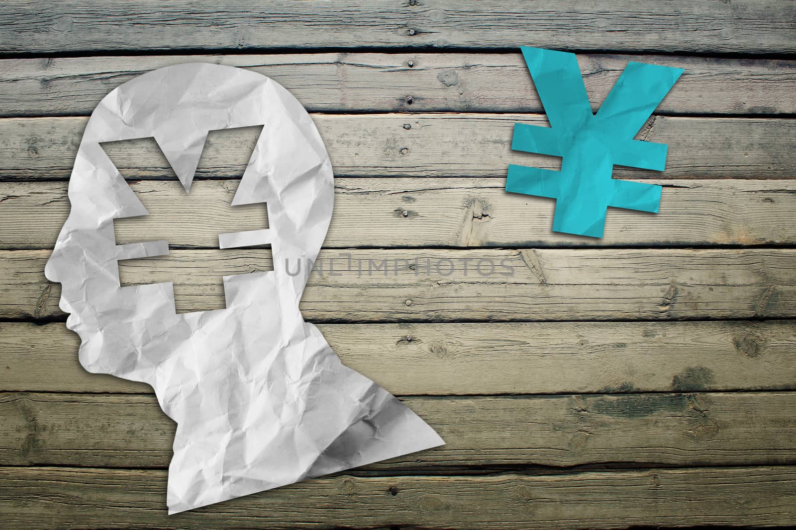Paper humans head with yen symbol on wood deck background