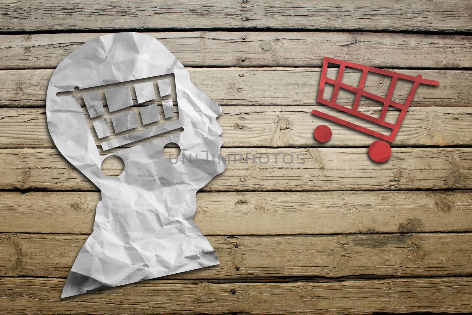 Paper humans head with shopping cart symbol on wood deck background