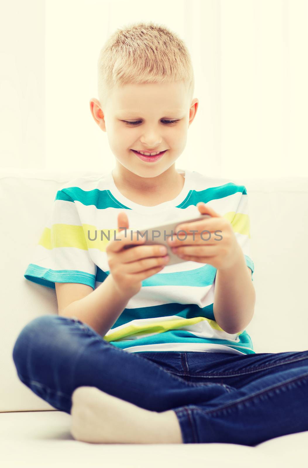 smiling little boy with smartphone by dolgachov