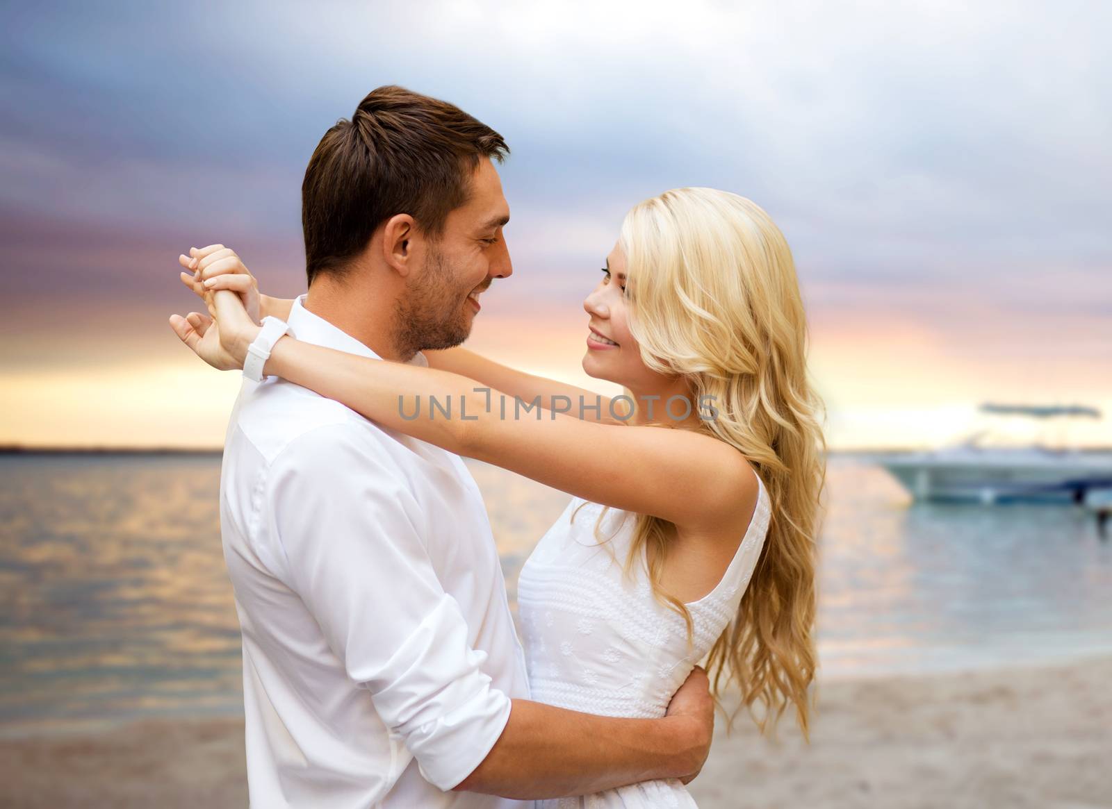 happy couple hugging over sunset beach background by dolgachov