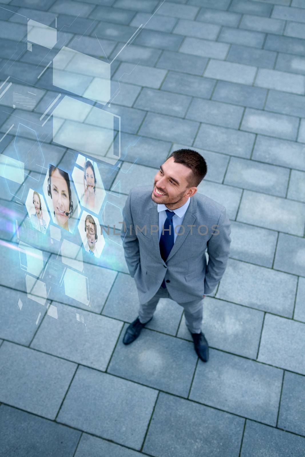 business, future technology and people concept - young smiling businessman with virtual screens using video chat outdoors from top