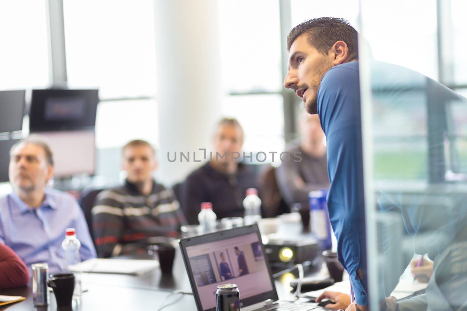 Business man making a presentation at office. Business executive delivering a presentation to his colleagues during meeting or in-house business training, explaining business plans to his employees.