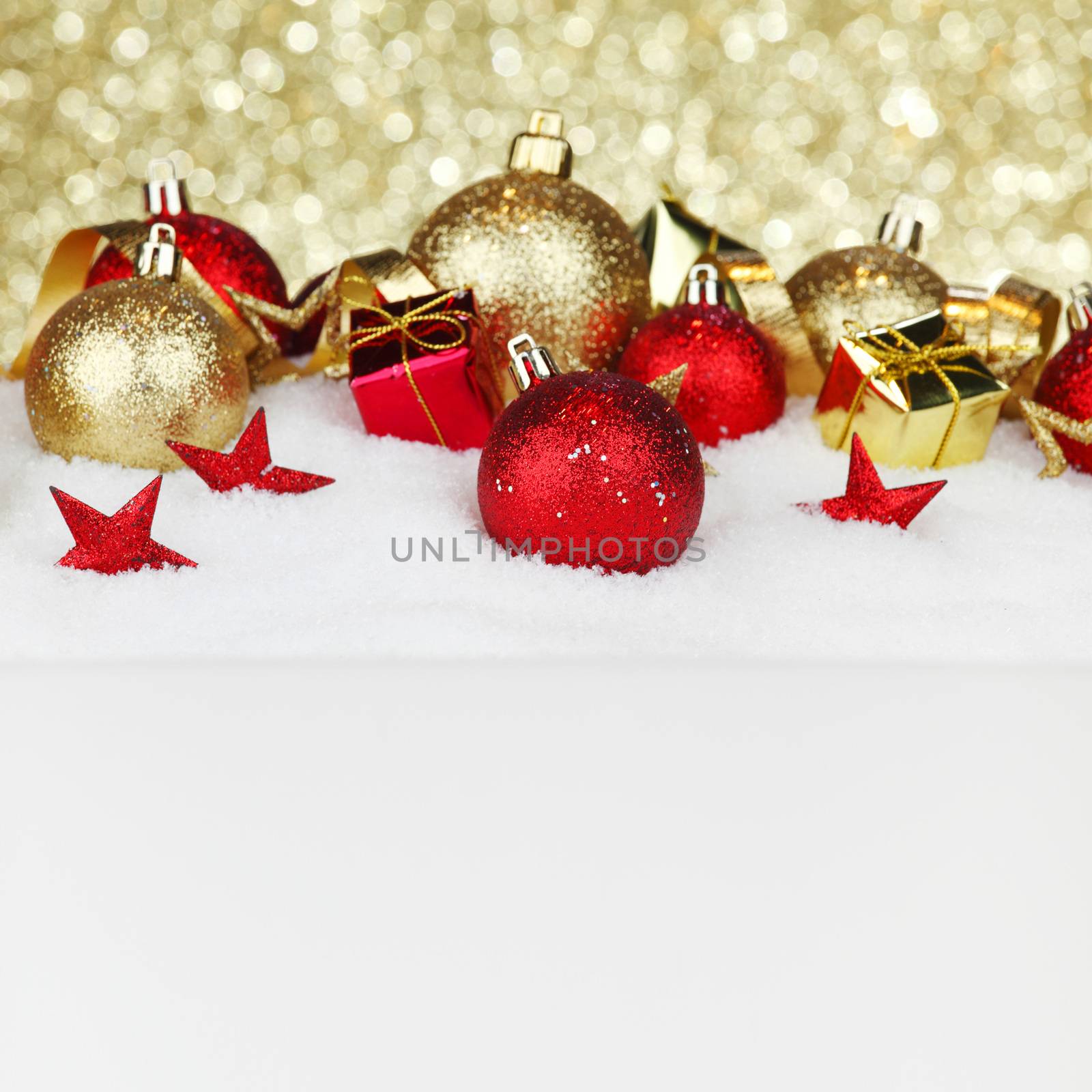 Red and golden christmas balls and decoration on snow