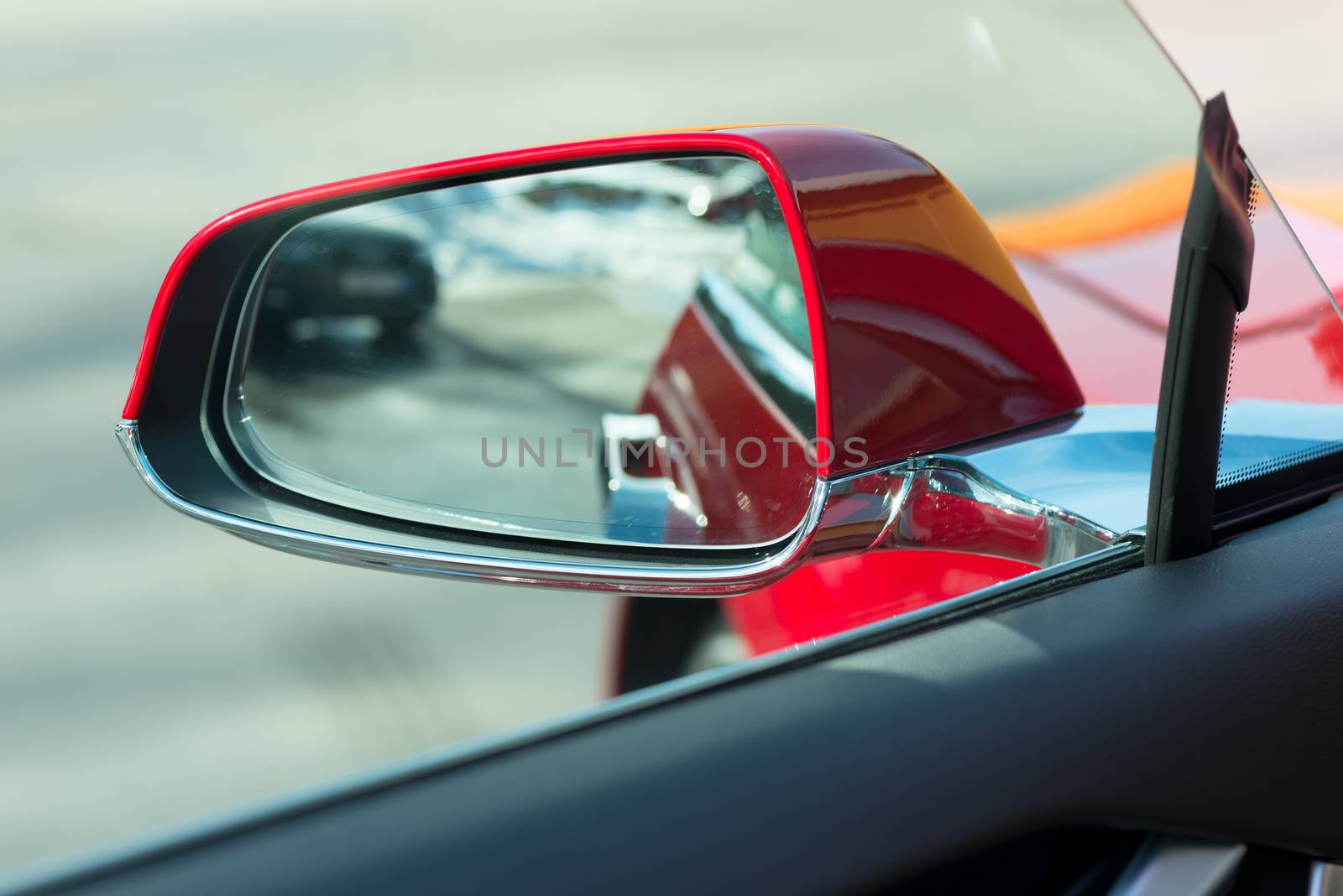 side rear-view mirror on a modern red car