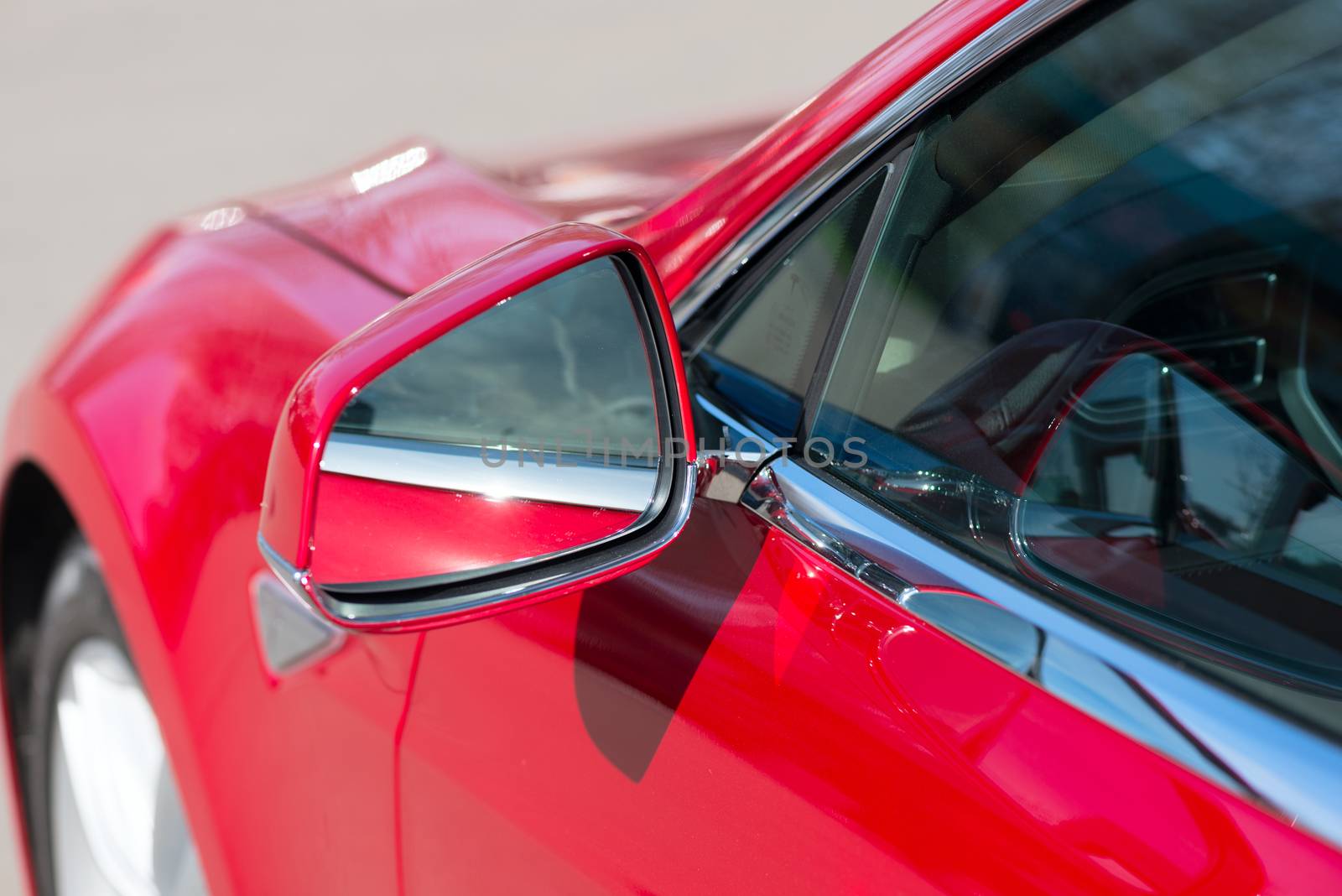 side rear-view mirror on a modern red car