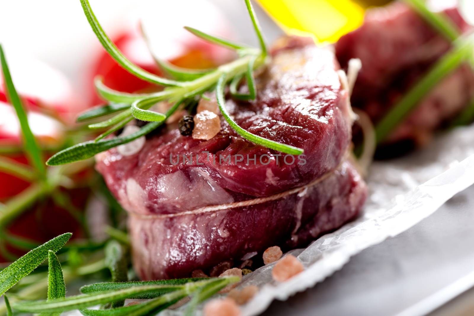 Raw beef steak with peppercorns and herbs