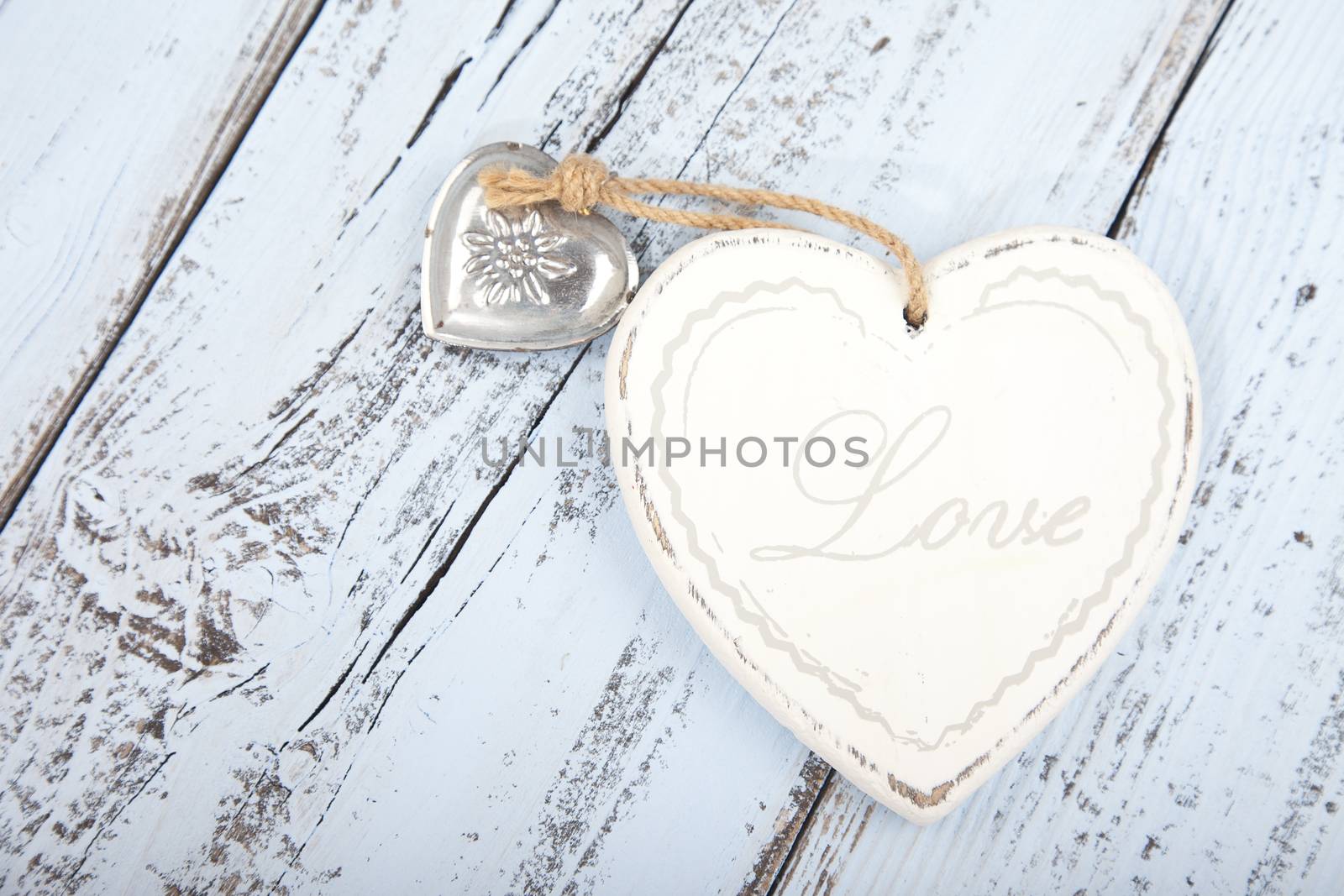 White heart with text Love on light blue wooden background